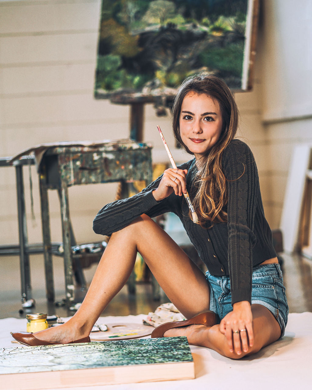 Artist AnnMarie Young working on a large scale landscape painting